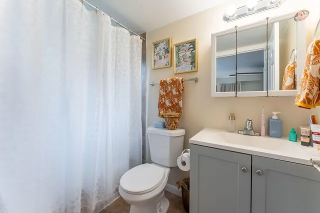 a bathroom with a toilet sink and mirror