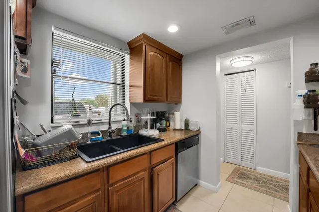 a kitchen with sink a window and cabinets