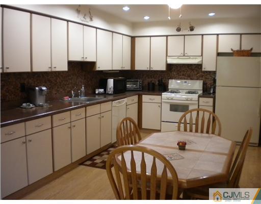 123 Redpine Loop Old Bridge, NJ 08857 - Photo 2 of 24 a kitchen with stainless steel appliances kitchen island granite countertop a refrigerator a sink a stove a dining table and chairs