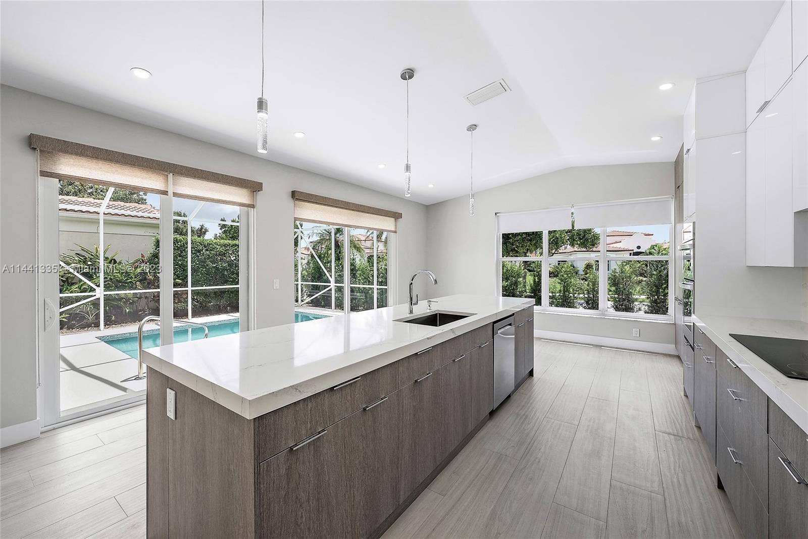 3670 Northwind Court Jupiter, FL 33477 - Photo 43 of 45 a large kitchen with kitchen island a large window a sink and stainless steel appliances