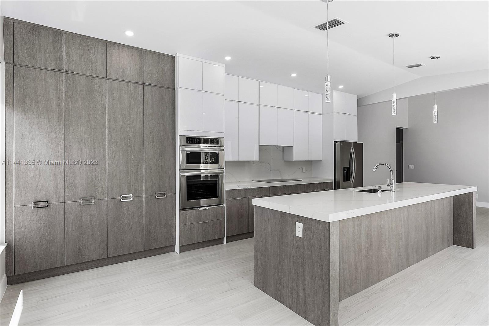 3670 Northwind Court Jupiter, FL 33477 - Photo 5 of 45 a large kitchen with a counter space a sink stainless steel appliances and cabinets