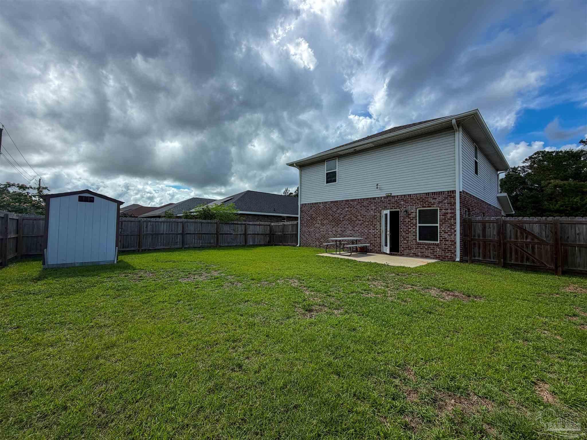 3613 Conley Drive Cantonment, FL 32533 - Photo 31 of 32 a backyard of a house with lots of green space and wooden fence
