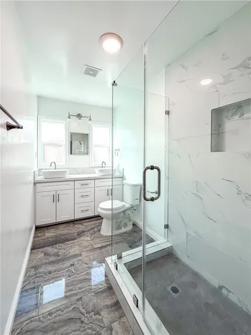 a bathroom with a double vanity sink a mirror and a shower