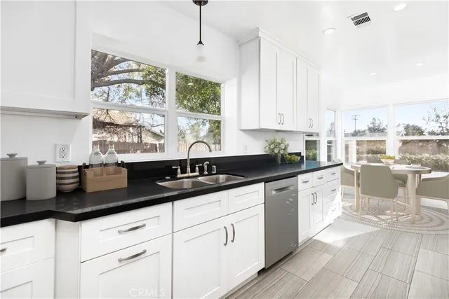 a kitchen with granite countertop white cabinets and white appliances
