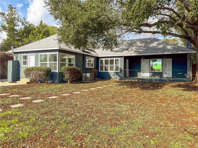 a front view of house with yard and trees around