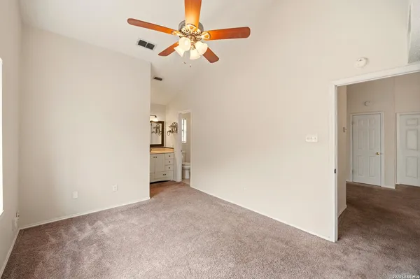 an empty room with chandelier fan and closet