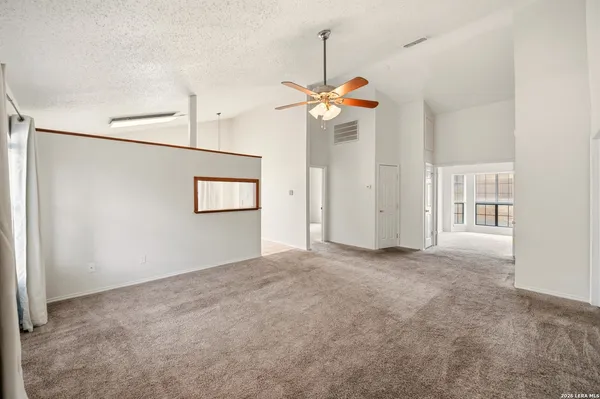an empty room with windows and ceiling fan