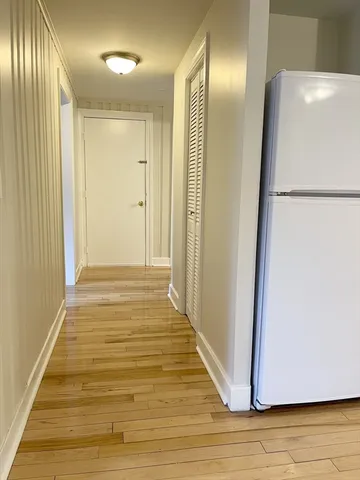a view of a hallway with wooden floor