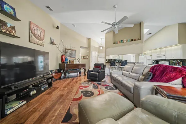a spacious bedroom with a bed a couch and large flat tv screen on the dresser
