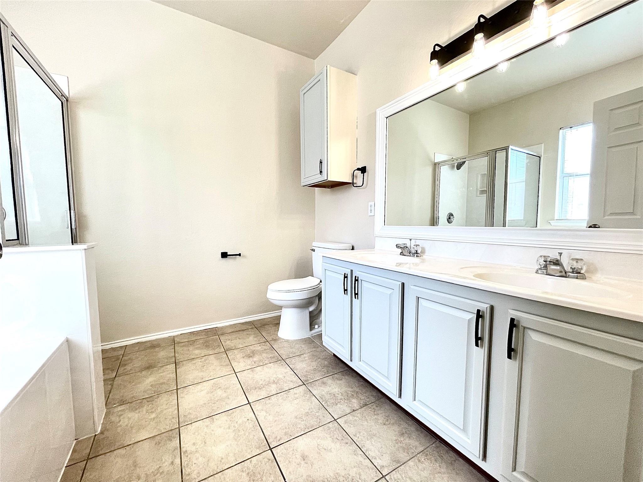 508 Emma Rose Trail Leander, TX 78641 - Photo 37 of 40 Double vanity sinks and tiled floors define this well-appointed bathroom space.