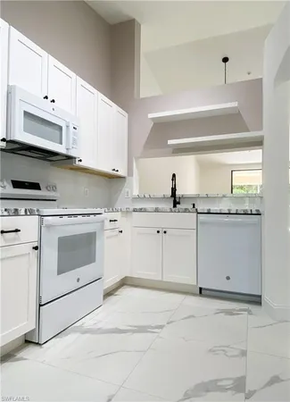a kitchen with cabinets stainless steel appliances and a window