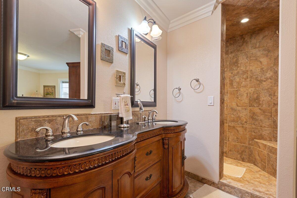 2131 Ravoli Drive Oxnard, CA 93035 - Photo 35 of 43 a bathroom with a sink a mirror a vanity and a shower