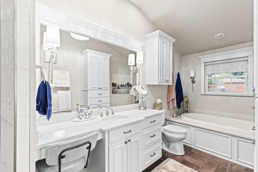 934 North Maple Street Muenster, TX 76252 - Photo 15 of 39 a bathroom with a granite countertop sink mirror vanity bathtub and a toilet