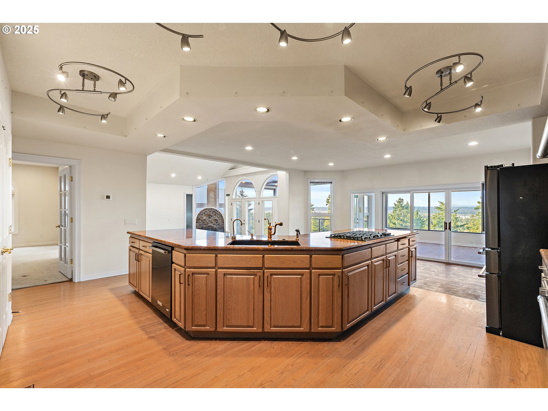9101 Northeast Cliff Street Portland, OR 97220 - Photo 5 of 26 a large kitchen with stainless steel appliances a large counter top a stove and a refrigerator