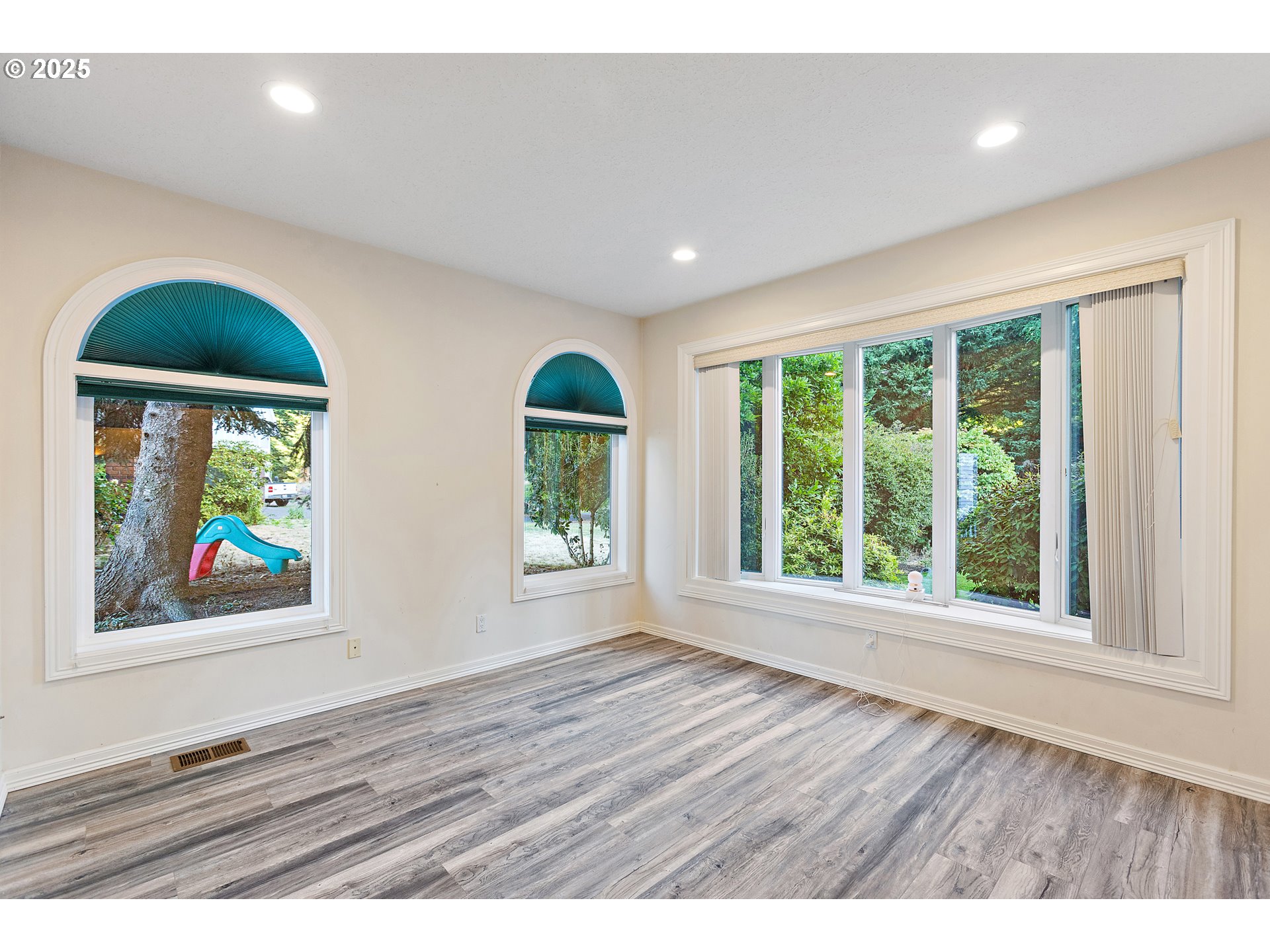 9101 Northeast Cliff Street Portland, OR 97220 - Photo 7 of 26 a view of an empty room with wooden floor and windows