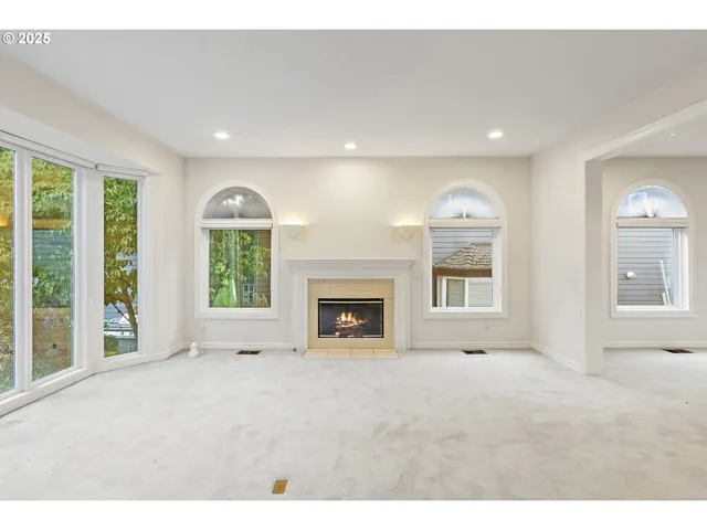 a view of an empty room with a window and a fireplace