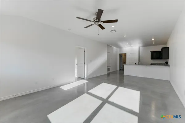 a living room with furniture and a view of kitchen