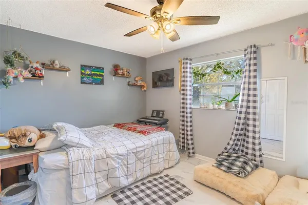 a bedroom with a bed and a window with wooden floor