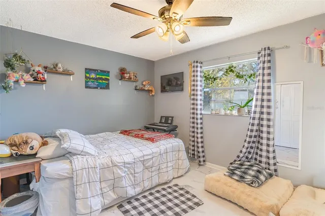 a bedroom with a bed and a window with wooden floor