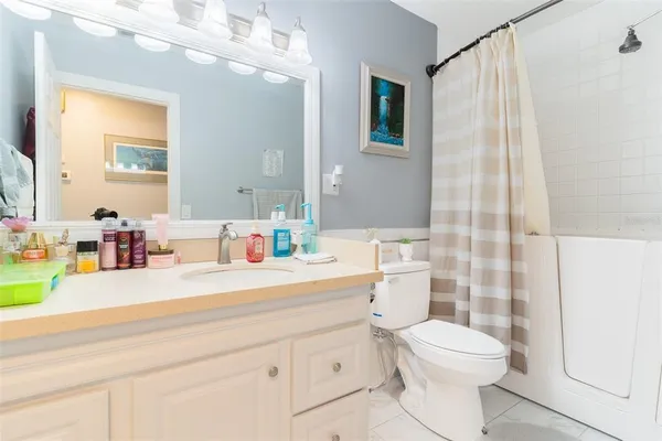 a bathroom with a sink a toilet and shower curtain