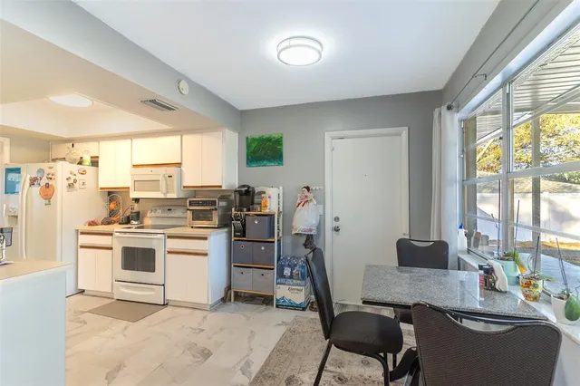 a kitchen with a stove a table and chairs