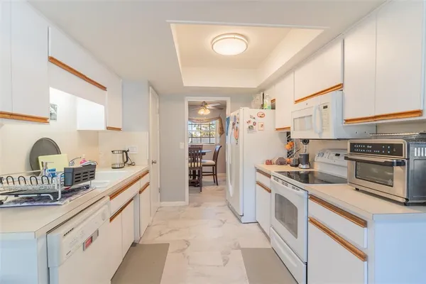 a kitchen with white cabinets and appliances