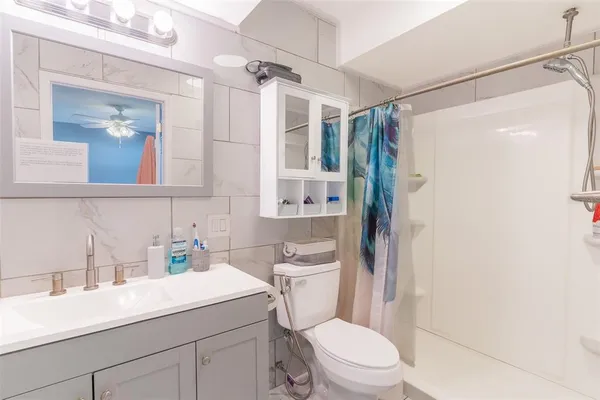 a bathroom with a sink a toilet a mirror a vanity and shower