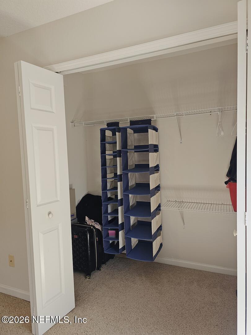 7826 Melvin Road Jacksonville, FL 32210 - Photo 15 of 17 a view of walk in closet with clothes and shoes