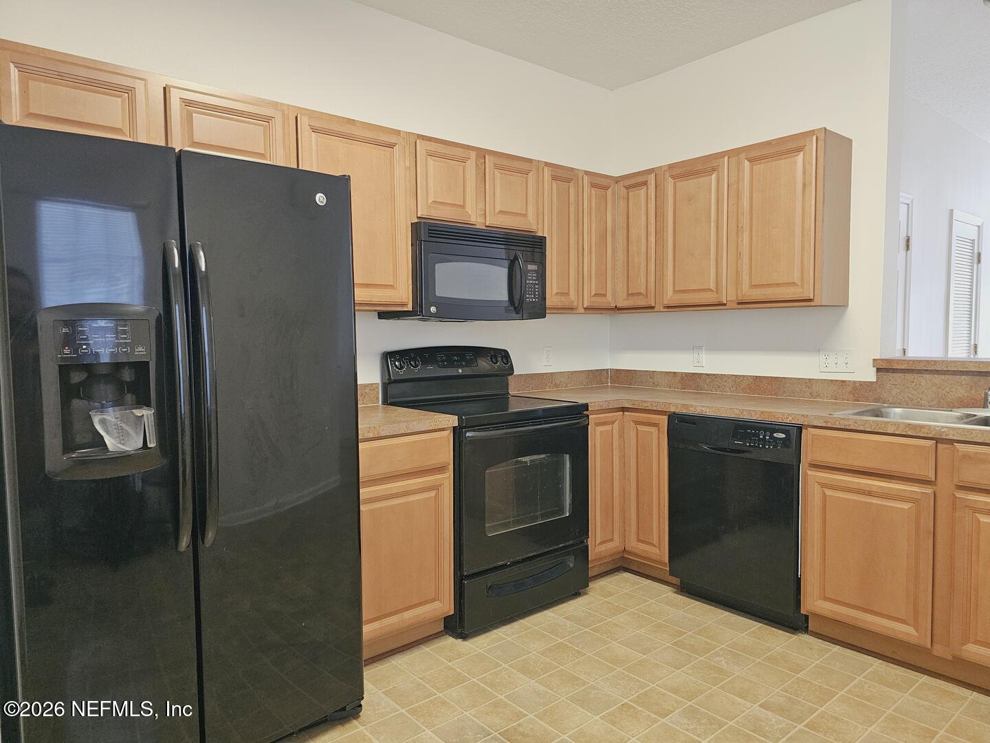 7826 Melvin Road Jacksonville, FL 32210 - Photo 3 of 17 a kitchen with stainless steel appliances granite countertop a refrigerator stove and sink