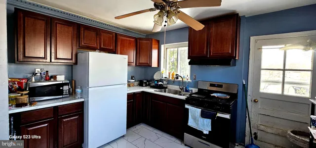 a kitchen with stainless steel appliances granite countertop wooden cabinets a refrigerator a sink and a stove