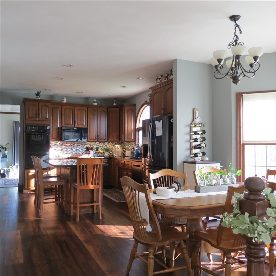 10160 Lochard Road Sidney, OH 45365 - Photo 11 of 41 This spacious kitchen and dining area features rich wood flooring, ample cabinetry, and modern appliances.