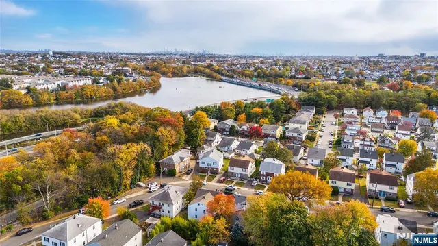 an aerial view of ocean and residential houses with outdoor space