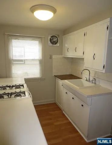 a kitchen with a sink stove and cabinets