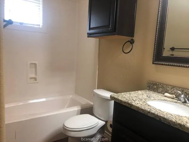 a white toilet sitting next to a bath tub