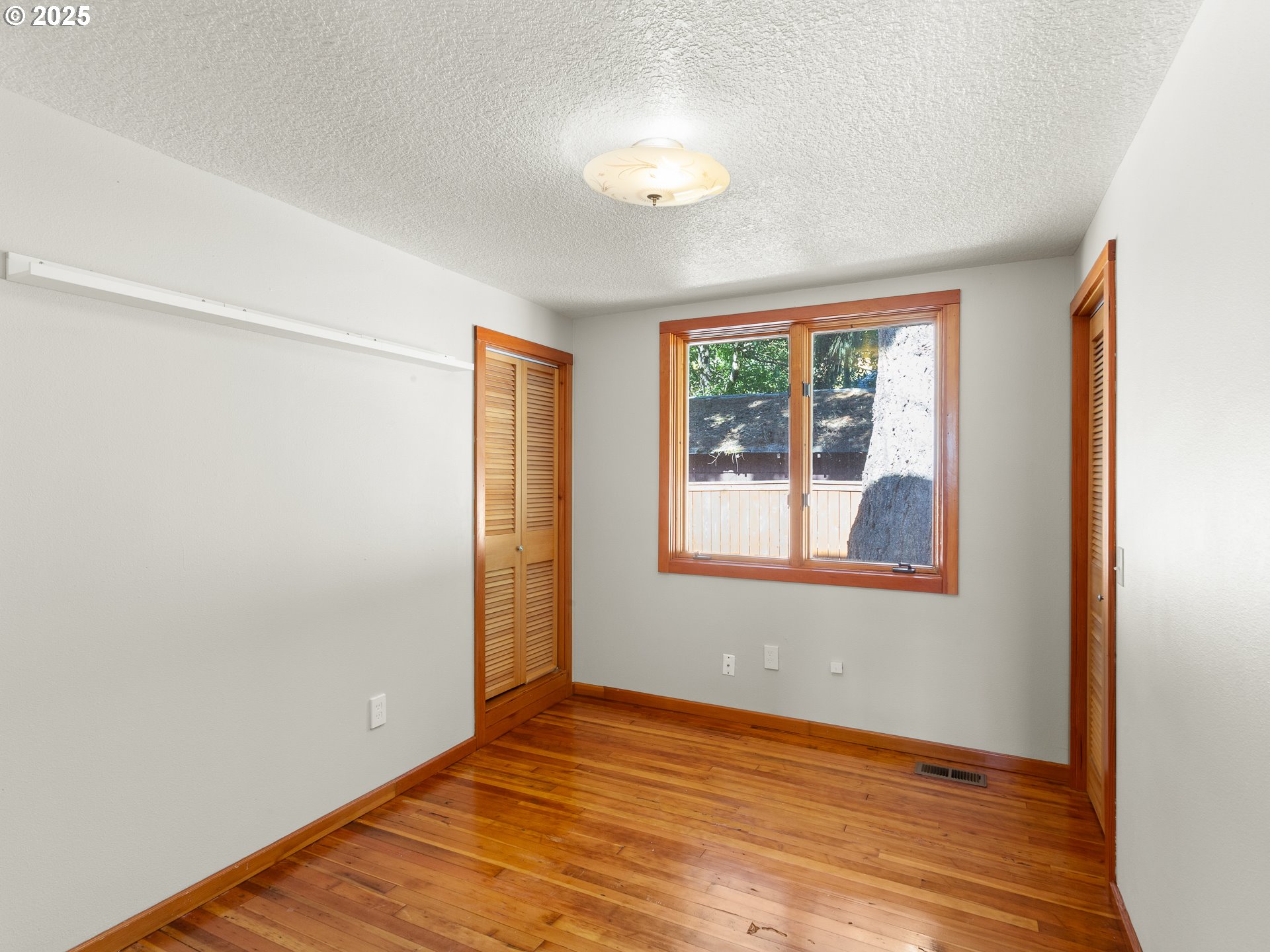 912 Northwest Fargo Street Camas, WA 98607 - Photo 16 of 44 an empty room with wooden floor and windows