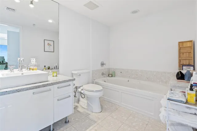 a bathroom with a granite countertop sink toilet a mirror and shower