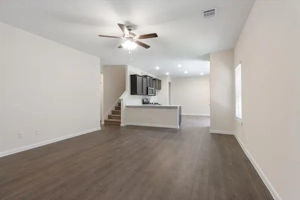 a view of a livingroom with a ceiling fan and wooden floor