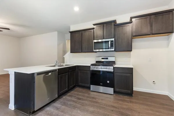 a kitchen with granite countertop wooden cabinets and stainless steel appliances
