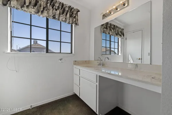 a bathroom with a granite countertop toilet and a sink