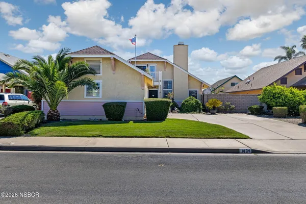 a front view of a house with a garden and yard