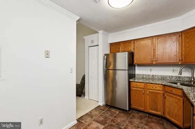 a kitchen with a refrigerator sink and cabinets