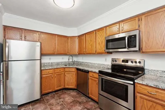 a kitchen with a sink a microwave a refrigerator and cabinets