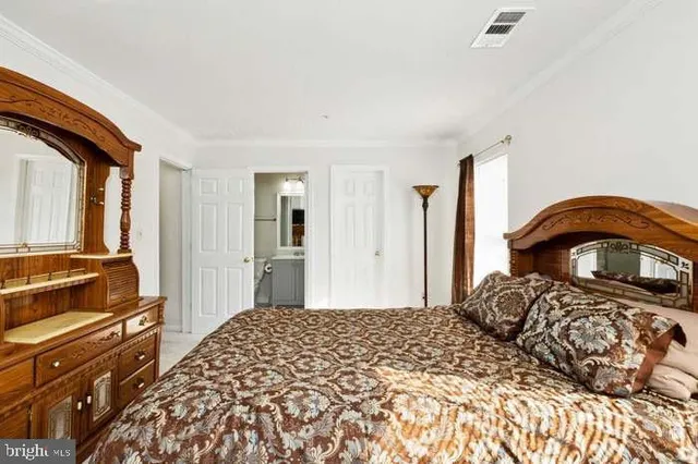 a bedroom with a bed and a dresser with mirror