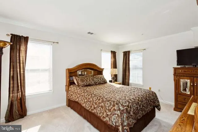 a bedroom with a bed and a flat tv screen on wall
