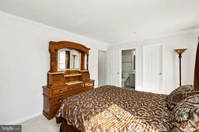 a bedroom with a bed and dresser with mirror