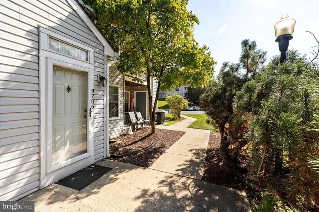 a view of a patio with table and chairs and floor to ceiling window