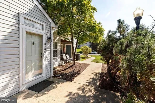 a view of a patio with table and chairs and floor to ceiling window