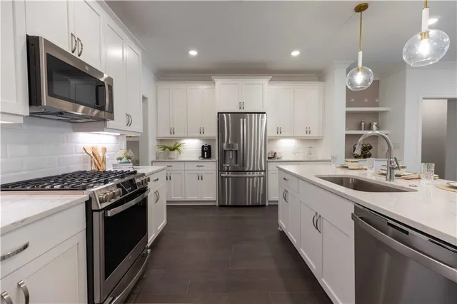 a kitchen with a sink stove microwave and refrigerator
