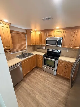 a kitchen with wooden cabinets and a stove top oven