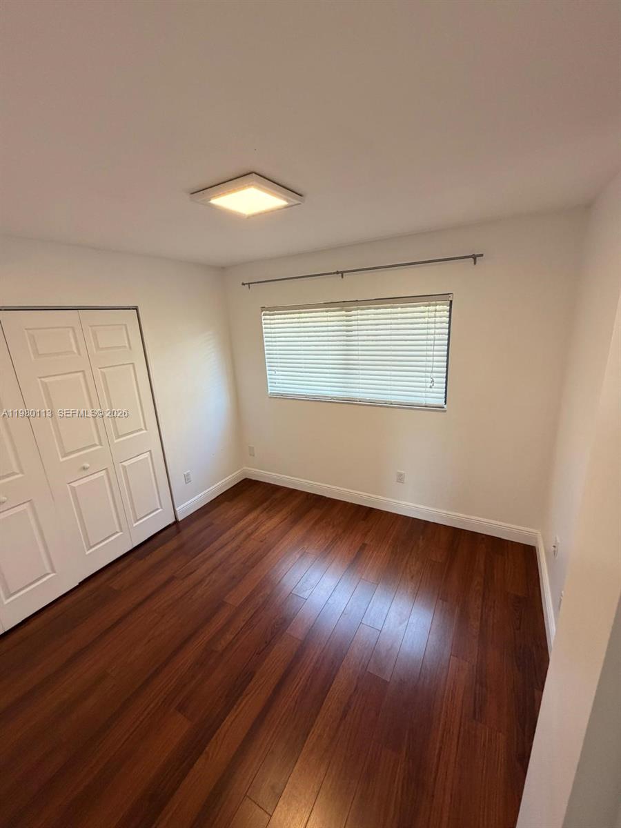 7101 Southwest 113th Court Miami, FL 33173 - Photo 12 of 30 an empty room with wooden floor and windows